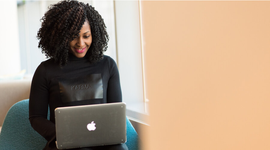 Woman looking and smiling at her laptop